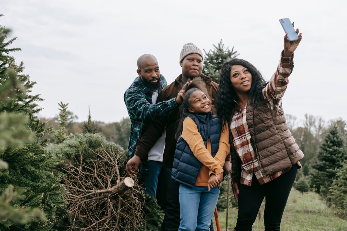 Happy black family taking selfie on smartphone